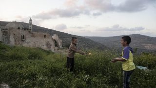 Image description: two children playing nearby a cultural heritage site in Palestine. Credit: RIWAQ.